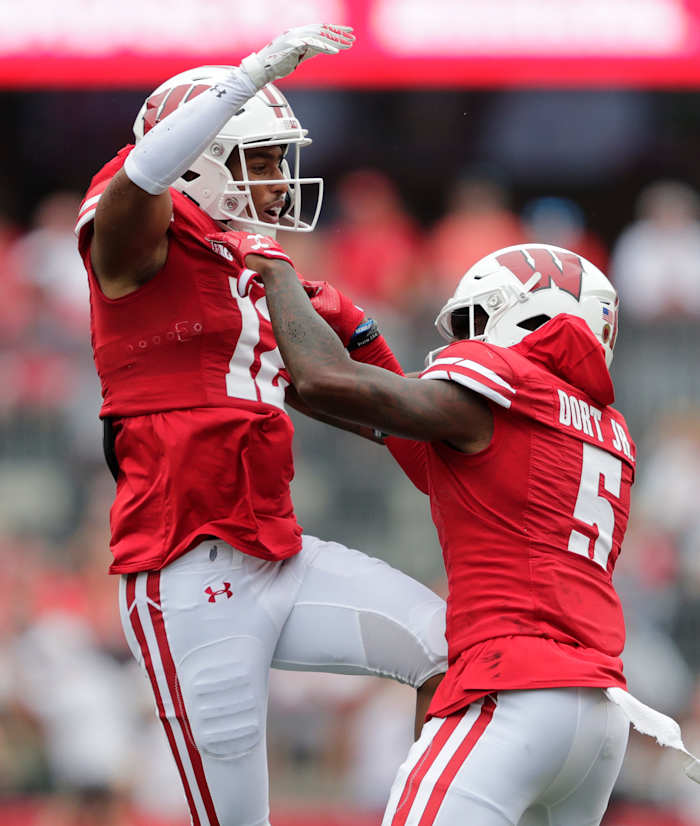 Wisconsin cornerback Max Lofy (No. 12) celebrates with a teammate after an interception versus Washington State